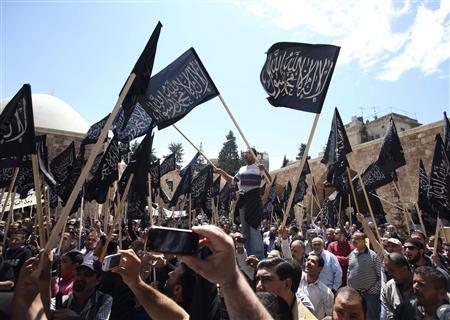 Supporters and members of Islamist party ''Hizb Ut-Tahrir'' wave their party's flags and chant slogans during a protest in Tripoli, northern Lebanon, to express solidarity with Syria's protesters, April 22, 2011. REUTERS/ Mohamed Azakir